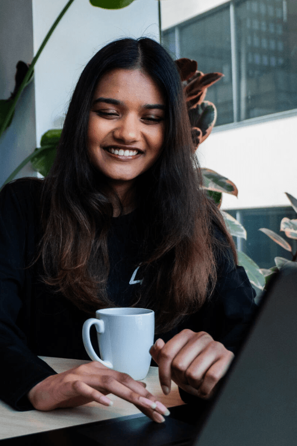Team member working on a laptop with coffee